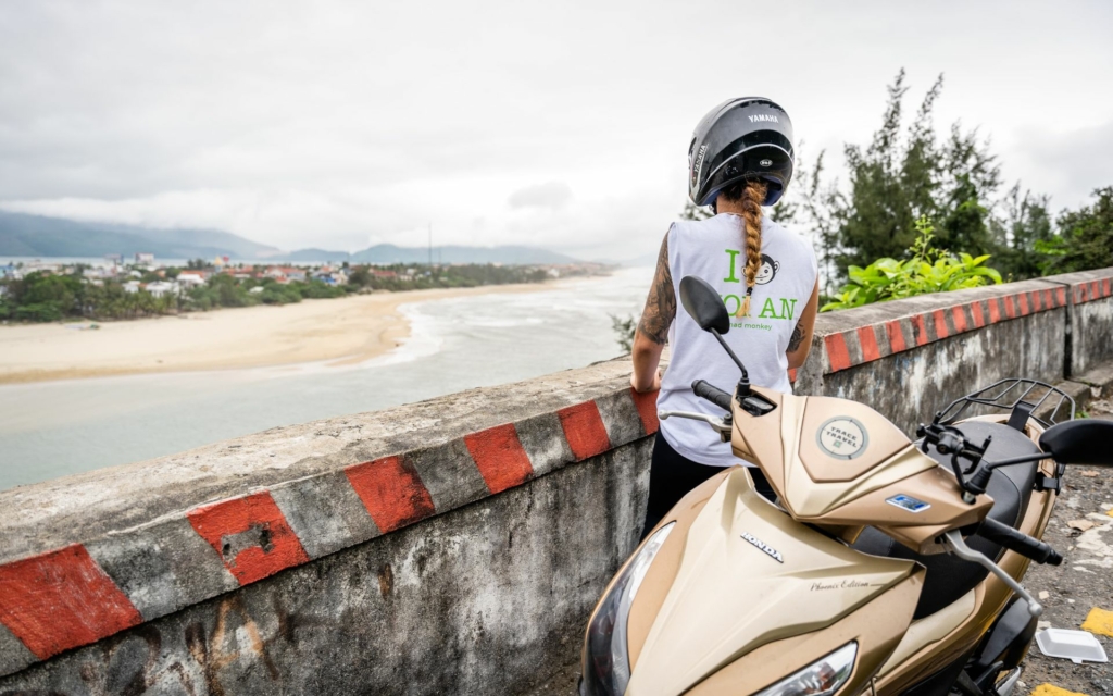 Backpacker exploring a coastal viewpoint by scooter on one of the Best Backpacker Routes.