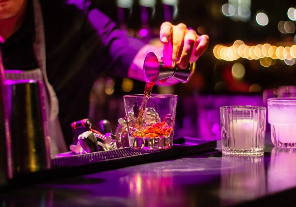 bartender pouring alcohol into a cup