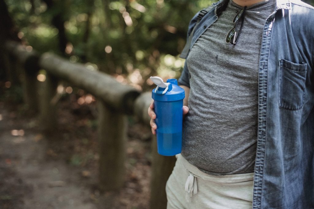 Man totes a reusable water bottle at Kuang Si Falls