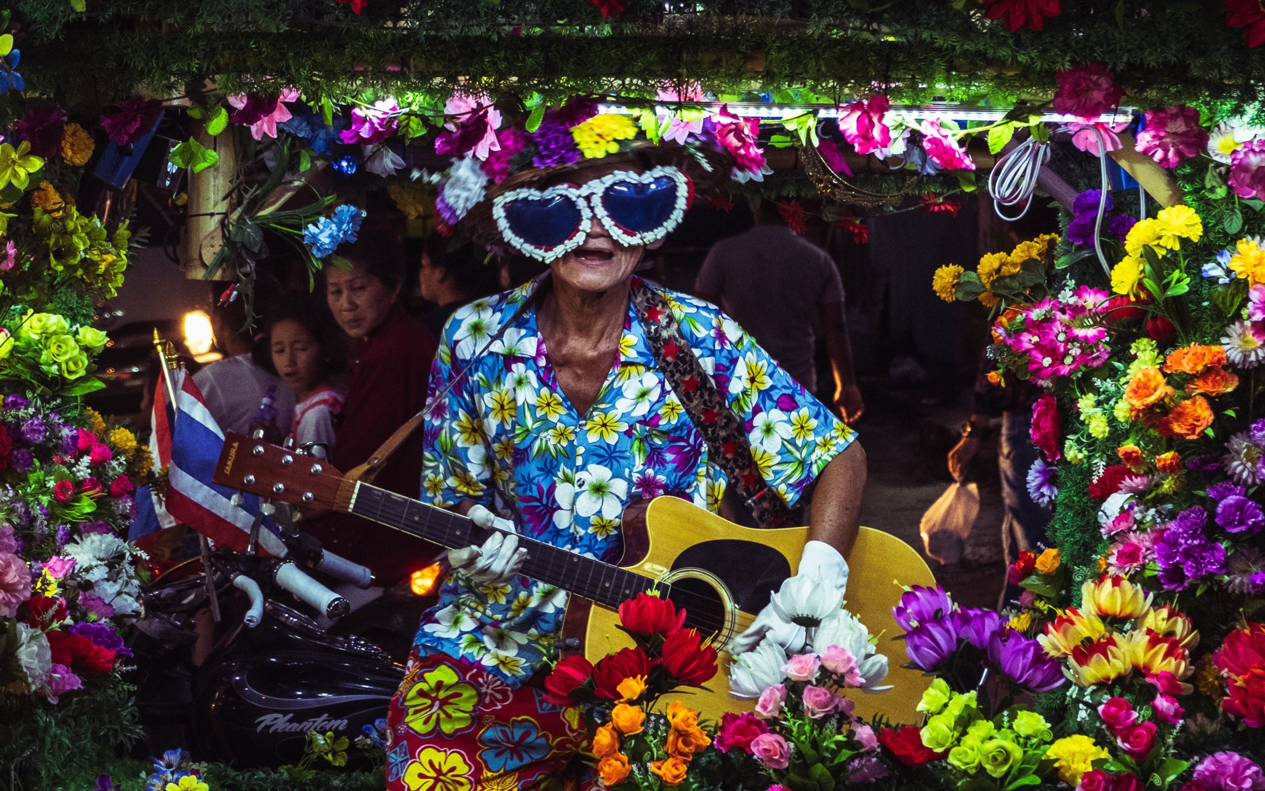 man busking in floral outfit in thailand tuktuk