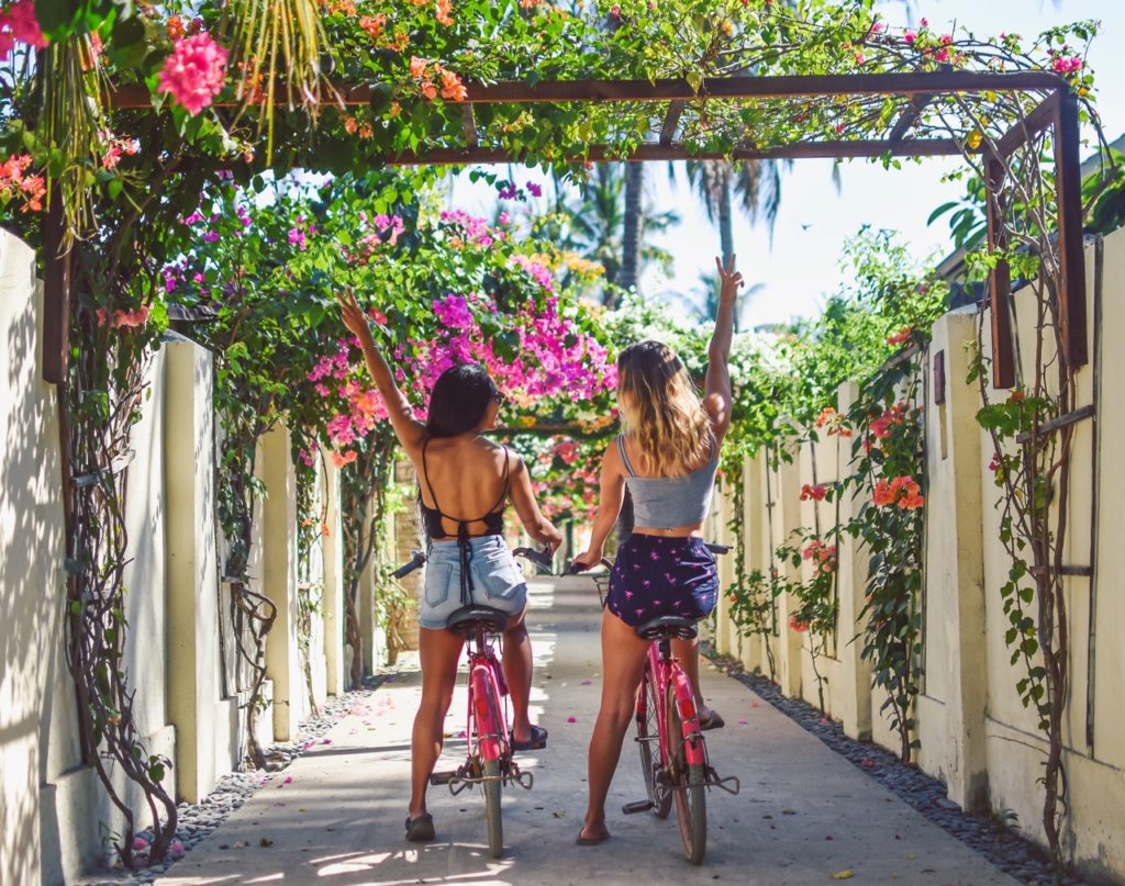 Backpackers exploring local streets by bike on the Mad Monkey Trail.