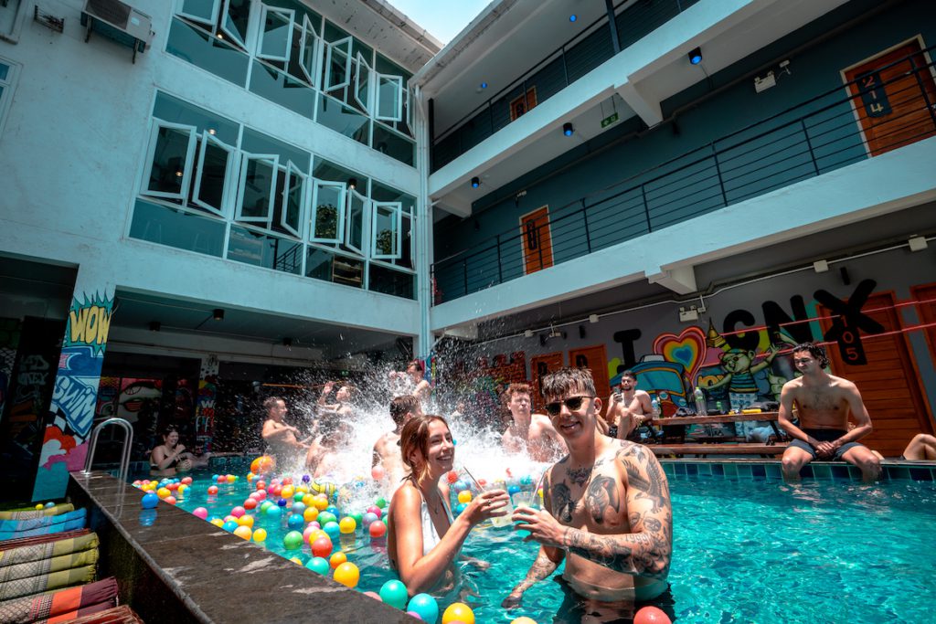 Backpackers cooling off in a Mad Monkey Chiang Mai pool on a Southeast Asia backpacking route