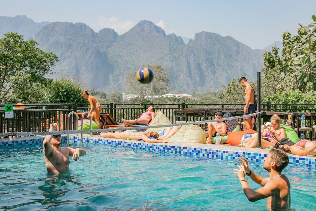 Travelers playing pool volleyball in Vang Vieng, Laos, on a Southeast Asia backpacking route.