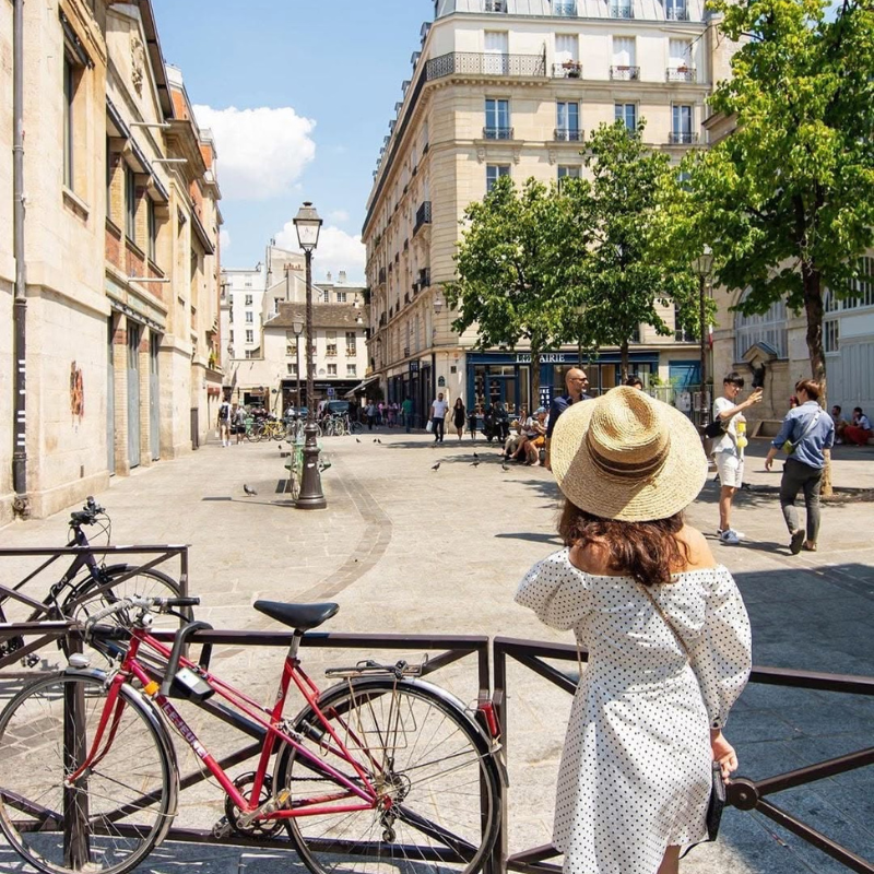 Traveler exploring a sunny Paris street near St Christopher’s Inn.