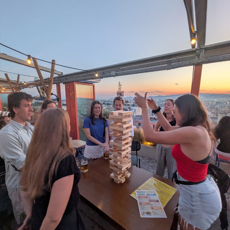 Travelers playing Jenga on a rooftop at YellowSquare, one of the social hostels in Europe.